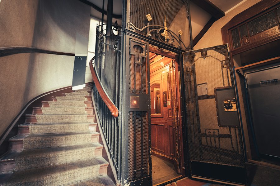 Ancien ascenseur à grille dans une cage d'escalier