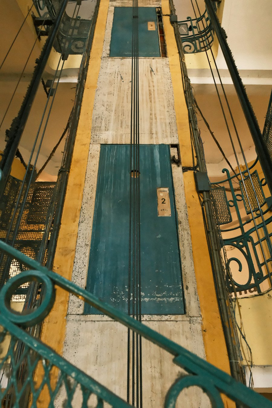 Ancien ascenseur à grille dans un immeuble